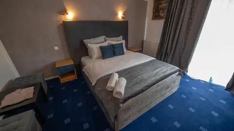 Double bed and bedside tables in the blue-carpeted room