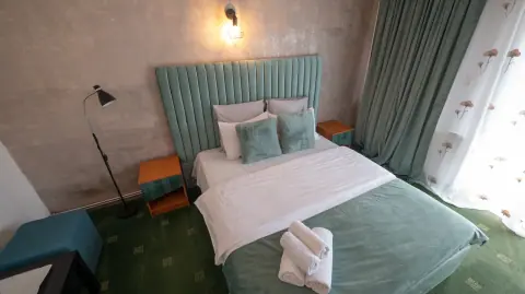 Double bed and furniture in the green-carpeted room
