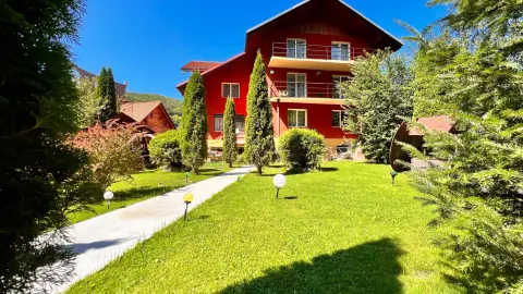 Top Mountain guesthouse with a red facade and garden path