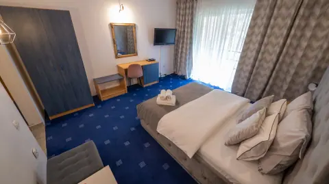 Double bed and room furniture viewed from the balcony side