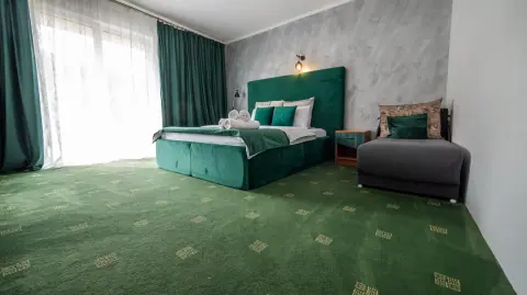 Double bed and armchair in the green room beside the balcony