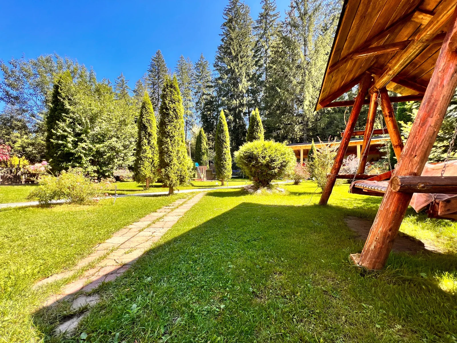 Gazon, alee și balansoar din lemn în grădina Top Mountain